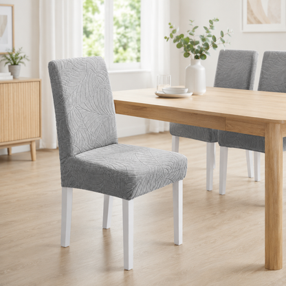 Naavian Gray grey textured chair cover on a chair in a room with a small table and decorative items.